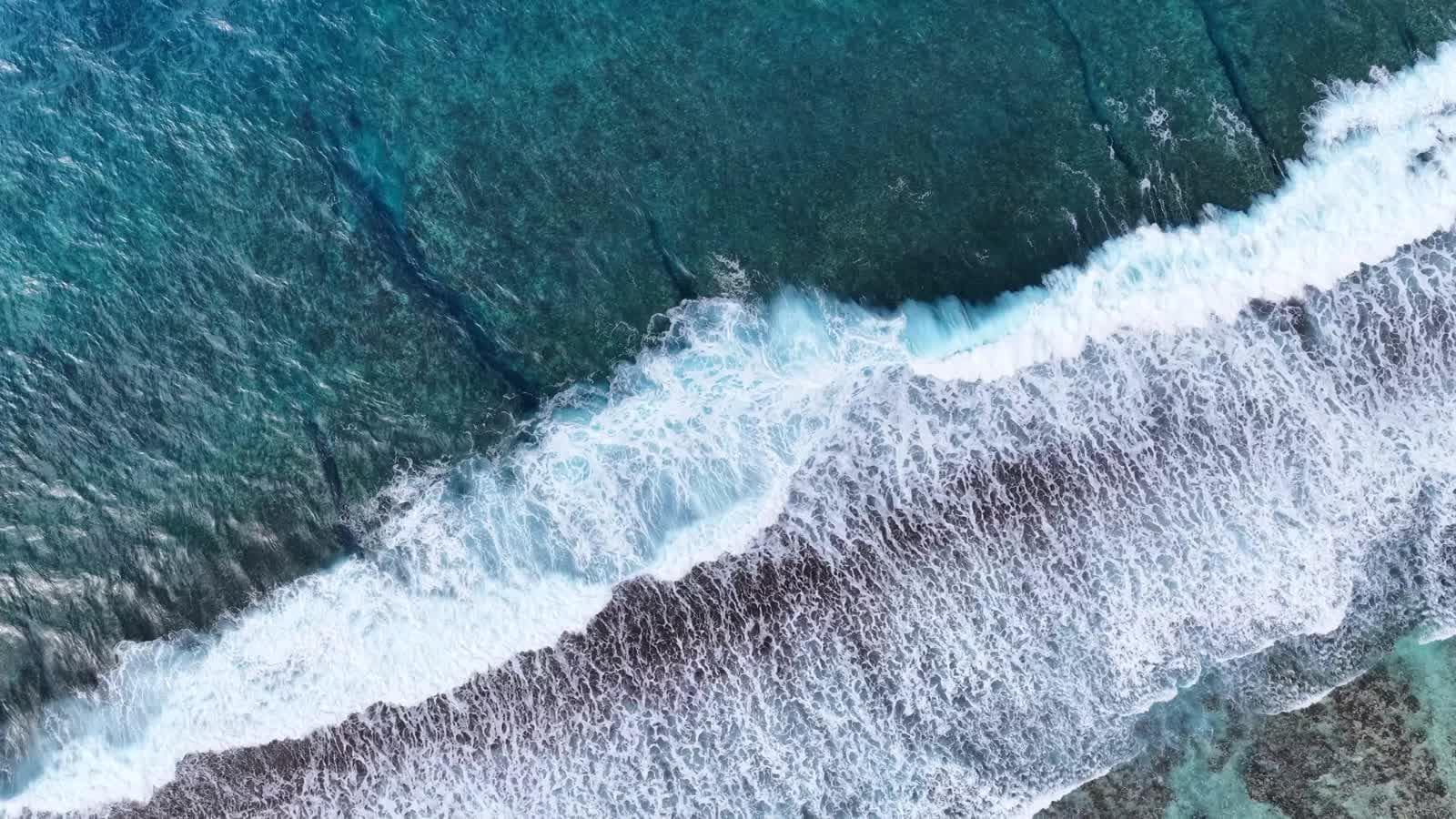 Drone footage of waves breaking over a coral reef